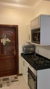a kitchen with a stove and a microwave at uhud view apartment in Al Madinah