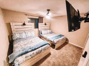 een slaapkamer met 2 bedden en een flatscreen-tv bij Pet Friendly/3 King Beds/Mins to Airport in Colorado Springs