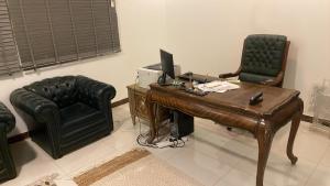 a office with a desk with a computer and a chair at uhud view apartment in Al Madinah