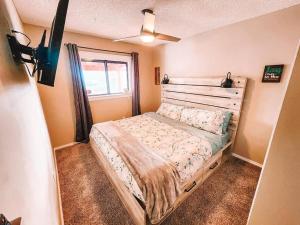 een slaapkamer met een bed, een ventilator en een raam bij Pet Friendly/3 King Beds/Mins to Airport in Colorado Springs