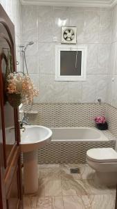 ein Badezimmer mit einer Badewanne, einem WC und einem Waschbecken in der Unterkunft uhud view apartment in Medina