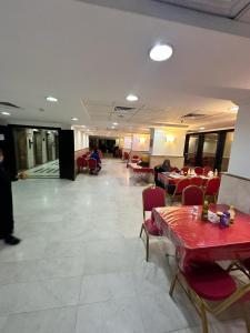 un restaurante con mesas y sillas y personas sentadas en mesas en ALBILAD ROYA HOTEL en Makkah