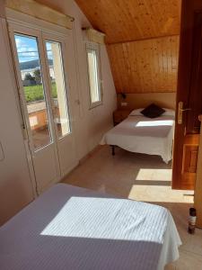 um quarto com 2 camas e uma grande janela em Casa Fraga em Foz