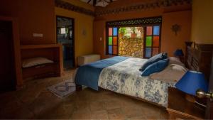 a bedroom with a bed with stained glass windows at Casas La Primavera in Villa de Leyva