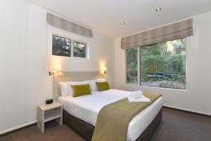 1 dormitorio con cama blanca y ventana en Aspen Court Franz Josef, en Franz Josef