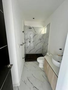 uma casa de banho branca com um WC e um lavatório em Tulum Zen Retreat, Prime location and amenities. em Tulum