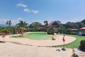 uma piscina no meio de um resort em COVEÑITAS Glamping con Aire Acondicionado y Piscina tipo PLAYA, Máximo 32 Personas em Melgar