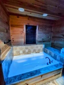 a large bath tub in a room with wooden walls at Perfectly Imperfect Cabin in Turtletown