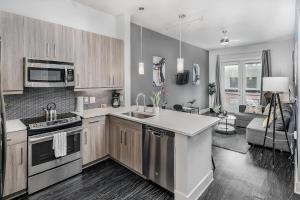 a kitchen with a sink and a stove top oven at Trifecta Luxury Serviced Apartment in Uptown CLT in Charlotte