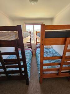 two bunk beds in a room with a window at RÚSTICA VIZCACHAS in Puente Alto