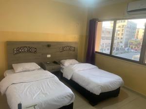 - 2 lits dans une chambre avec fenêtre dans l'établissement Best hotel aqaba, à Aqaba