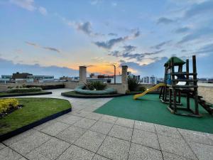 einen Spielplatz mit Rutsche und Riesenstuhl in der Unterkunft SkyLine Mountains Sauna Gym Luxury Apto in Bogotá