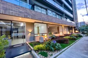 ein Gebäude mit einem Garten davor in der Unterkunft SkyLine Mountains Sauna Gym Luxury Apto in Bogotá