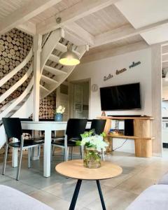 a living room with a table and chairs and a tv at A 154 Z Panoramą- Kaszubska Ostoja in Barkocin