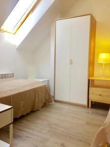 a bedroom with a bed and a cabinet and a skylight at A 154 Z Panoramą- Kaszubska Ostoja in Barkocin
