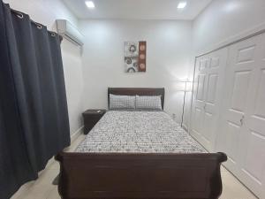 a bedroom with a bed and a white door at Caribbean Nest, West End, Roatan in West End