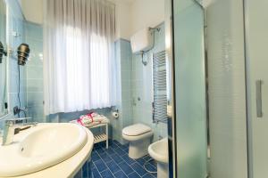 a blue bathroom with a sink and a toilet at Tito Livio Luxury B&B in Pozzuoli