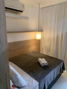 a room with a bed with two towels on a table at Apartamento mezanino Villas do pratagy in Maceió