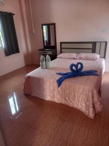 Un dormitorio con una cama con una cinta azul. en Phujhaofa villa club ( ไสยวน), en Ban Saiyuan (1)