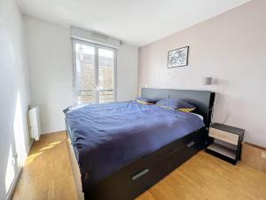 - une chambre avec un grand lit et une couette bleue dans l'établissement Theo's Bubble - Paris & Disney!, à Rosny-sous-Bois