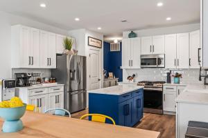 a kitchen with white cabinets and blue appliances at Beach House Steps away from the Boardwalk and Beach with Ocean Views in Seaside Heights! in Seaside Heights