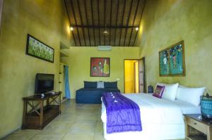 1 dormitorio con 1 cama grande y TV en Villa Jeruk I 2 Bedrooms Umalas Canggu, en Canggu
