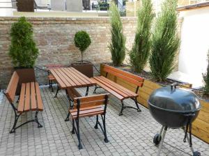 - un barbecue, des tables de pique-nique et des bancs sur une terrasse dans l'établissement Wile West Apartments, à Vienne