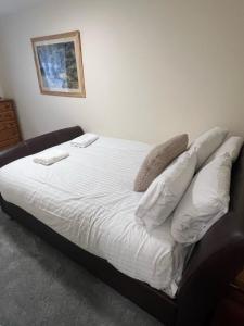 Una cama con sábanas blancas y almohadas. en Brilliantly Located 2BD Flat Heart of Edinburgh! en Edimburgo