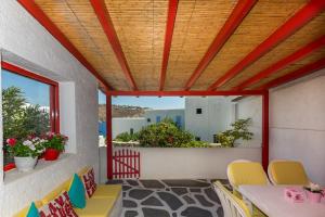 a patio with a table and chairs and a balcony at PARIS HOUSE in Mikonos