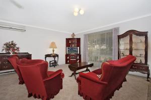 a living room with red chairs and a table at Wood Street Central - Central location! in Bright