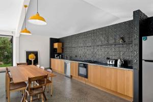 a kitchen with a wooden table and a dining room at Moosewood House, Kangaroo Valley in Kangaroo Valley