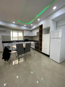 a kitchen with a table and chairs and a refrigerator at Zitouna Premier in Sousse