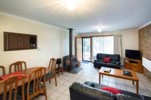 ein Wohnzimmer mit einem Sofa und einem Tisch in der Unterkunft Grampians View Cottages and Units in Halls Gap