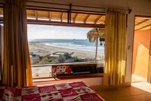 een slaapkamer met uitzicht op het strand vanuit een raam bij LA PUNTA LOBITOS HOTEL in Talara