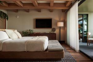 a bedroom with a bed and a tv on the wall at 1 Hotel Hanalei Bay in Princeville