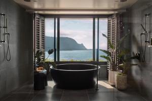 a bathroom with a large tub in front of a window at 1 Hotel Hanalei Bay in Princeville