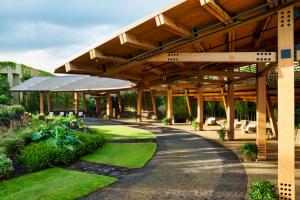 a building with a large wooden roof with a walkway at 1 Hotel Hanalei Bay in Princeville