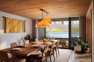 a dining room with a large wooden table and chairs at 1 Hotel Hanalei Bay in Princeville