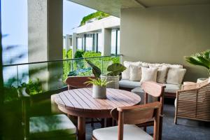 a balcony with a couch and a table and chairs at 1 Hotel Hanalei Bay in Princeville