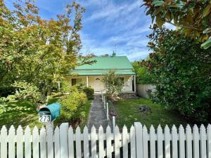 una cerca blanca frente a una casa en Maple Grove en Katoomba