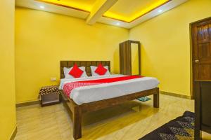 - une chambre avec un lit et des oreillers rouges dans l'établissement OYO Flagship Peppy Guest House, à Calangute