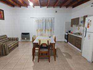 uma cozinha e sala de jantar com uma mesa e um frigorífico em Departamentos teuli em Puerto San Julian