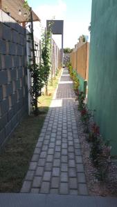 a brick path in a yard next to a wall at Jardim dos Milagres Suítes in São Miguel dos Milagres