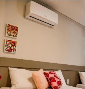 een kamer met een bank en airconditioning aan de muur bij Pousada Praiana in Porto De Galinhas