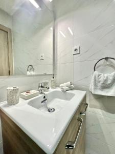 um banheiro branco com uma pia e um espelho em Condo in marrakech with pool em Marraquexe