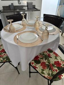 una mesa blanca con platos y utensilios. en Residencial Paraiso en Sinop