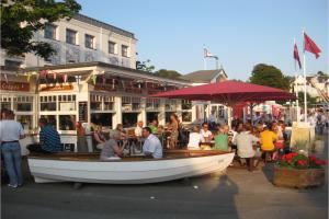 un grupo de personas sentadas en un barco frente a un restaurante en Alexa, en Laboe
