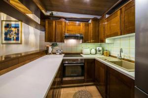 a kitchen with wooden cabinets and a white counter top at Family friendly house with a swimming pool Klis, Split - 21656 in Klis