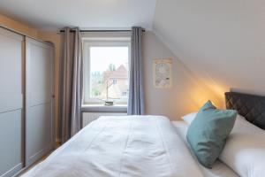 1 dormitorio con 1 cama grande y ventana en Bräist Hus, en Bredstedt