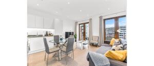 a kitchen and living room with a couch and a table at Metropolitan Luxury: Chic 2BR Flat in St. Albans in St. Albans